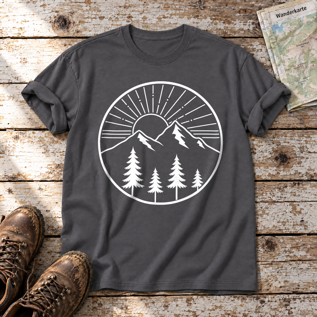 Bergmorgen – T-Shirt Unisex in Dunkelgrau, flach liegend auf alten Holzbrettern mit Wanderschuhen und Wanderkarte.