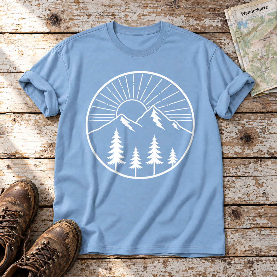 Bergmorgen – T-Shirt Unisex in Himmelblau, flach liegend auf alten Holzbrettern mit Wanderschuhen und Wanderkarte.