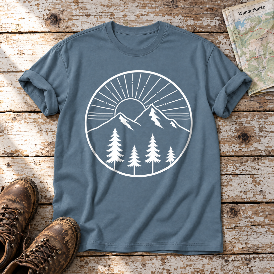 Bergmorgen – T-Shirt Unisex in Steinblau, flach liegend auf alten Holzbrettern mit Wanderschuhen und Wanderkarte.