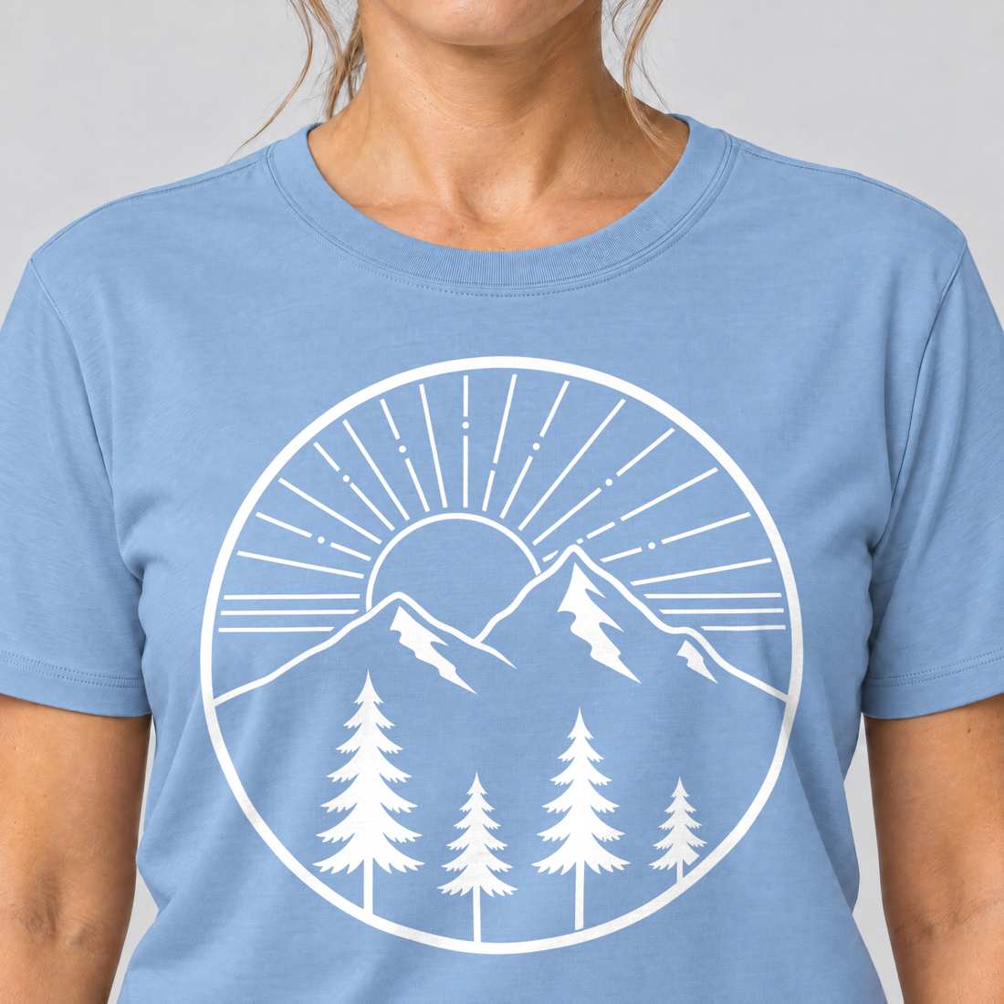 Nahaufnahme des Drucks: Bergmorgen – T-Shirt Unisex in Himmelblau, von einer Frau getragen