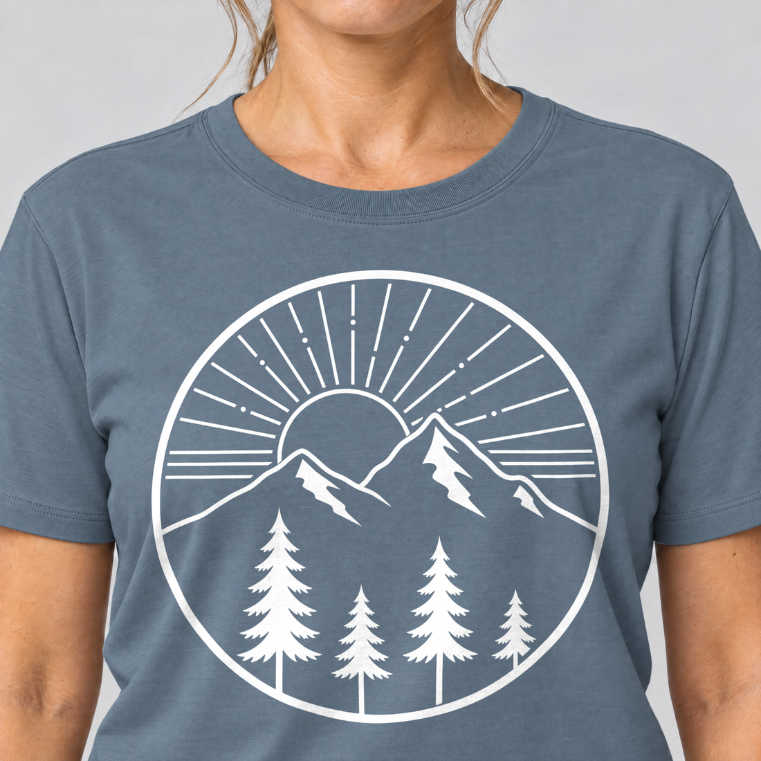 Nahaufnahme des Drucks: Bergmorgen – T-Shirt Unisex in Steinblau, von einer Frau getragen