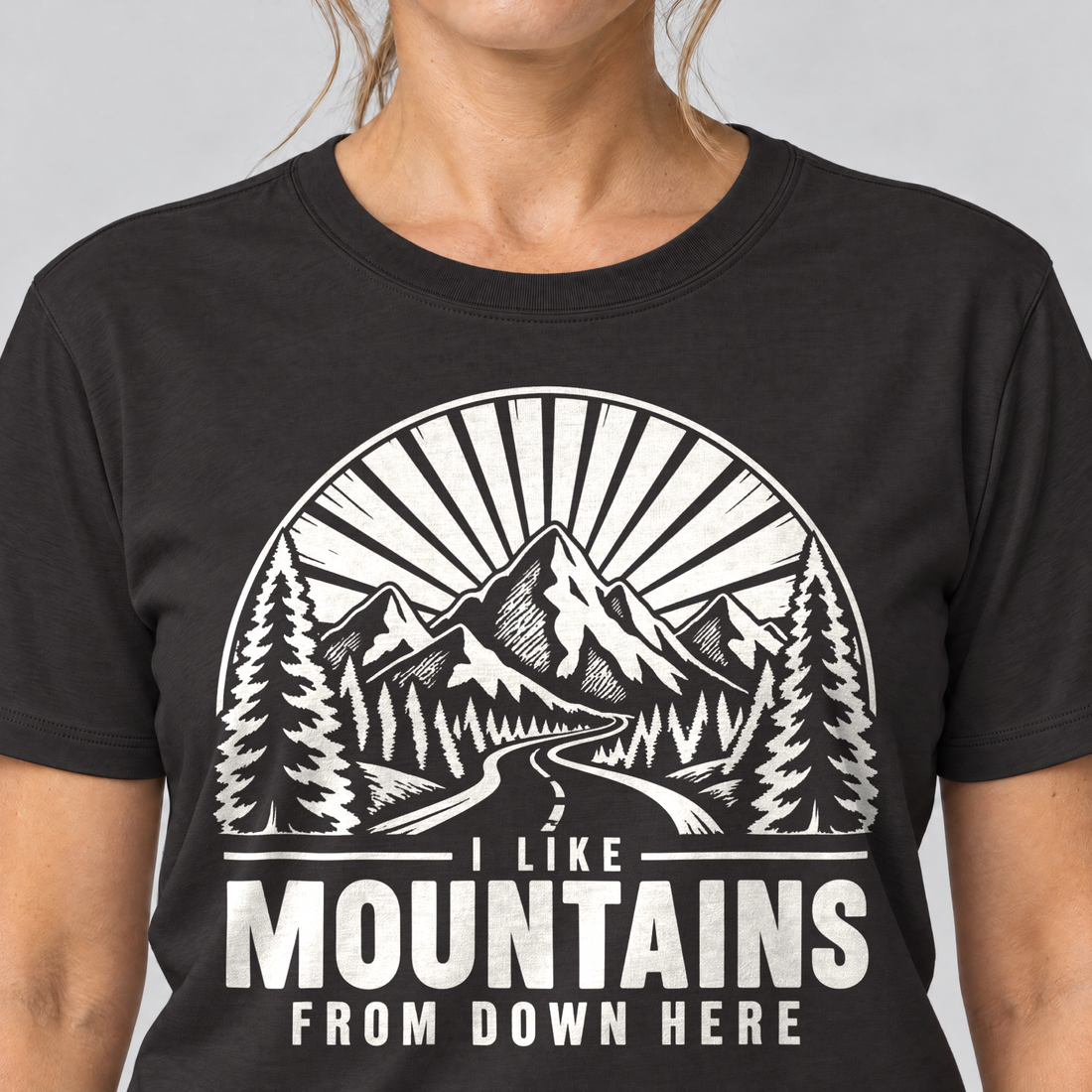 Nahaufnahme des Drucks: I like mountains from down here – T-Shirt Unisex in Schwarz, von einer Frau getragen