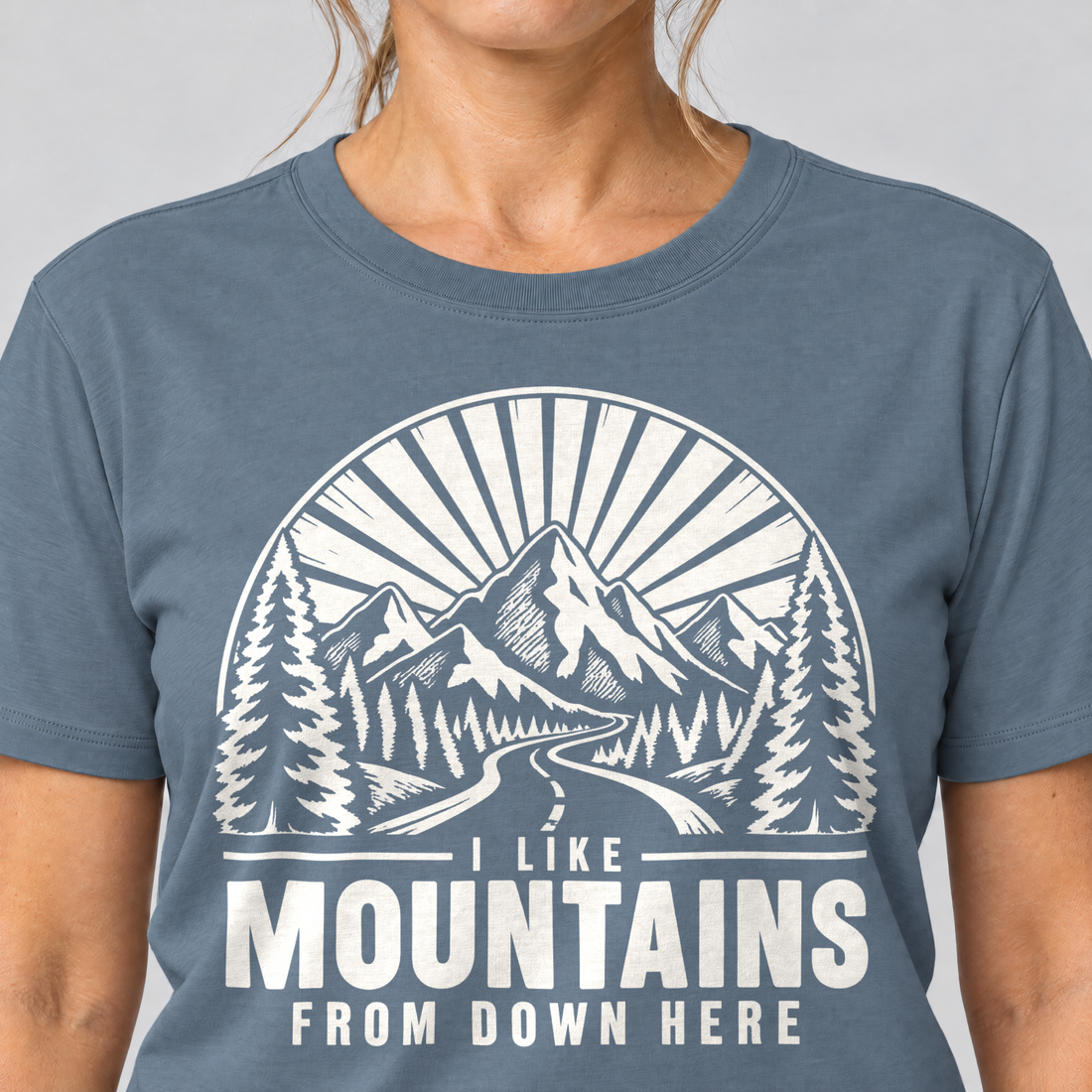 Nahaufnahme des Drucks: I like mountains from down here – T-Shirt Unisex in Steinblau, von einer Frau getragen
