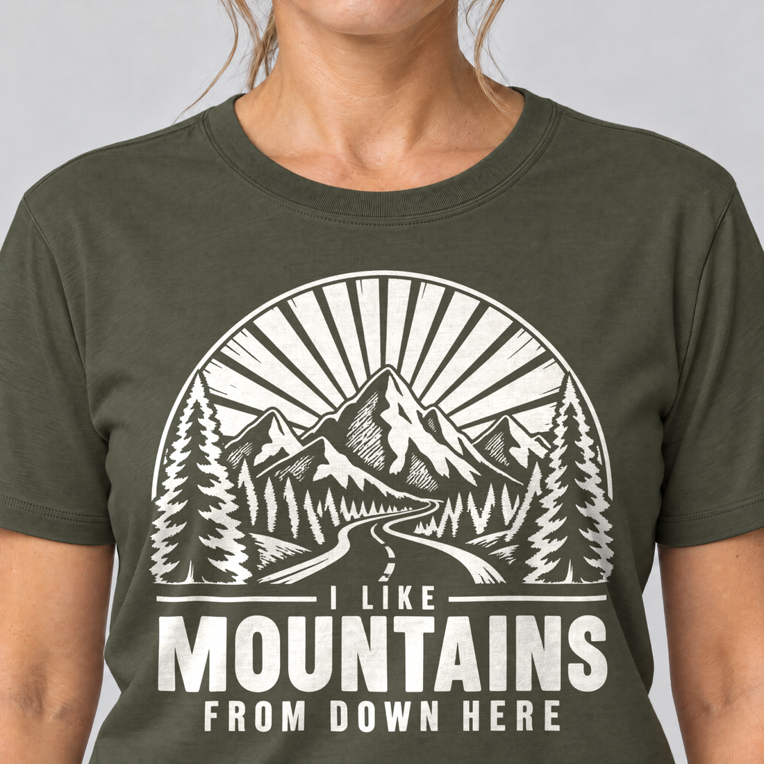 Nahaufnahme des Drucks: I like mountains from down here – T-Shirt Unisex in Oliv, von einer Frau getragen