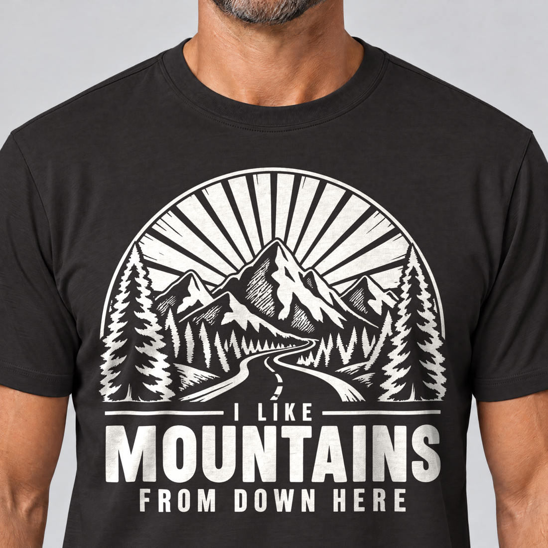 Nahaufnahme des Drucks: I like mountains from down here – T-Shirt Unisex in Schwarz, von einem Mann getragen