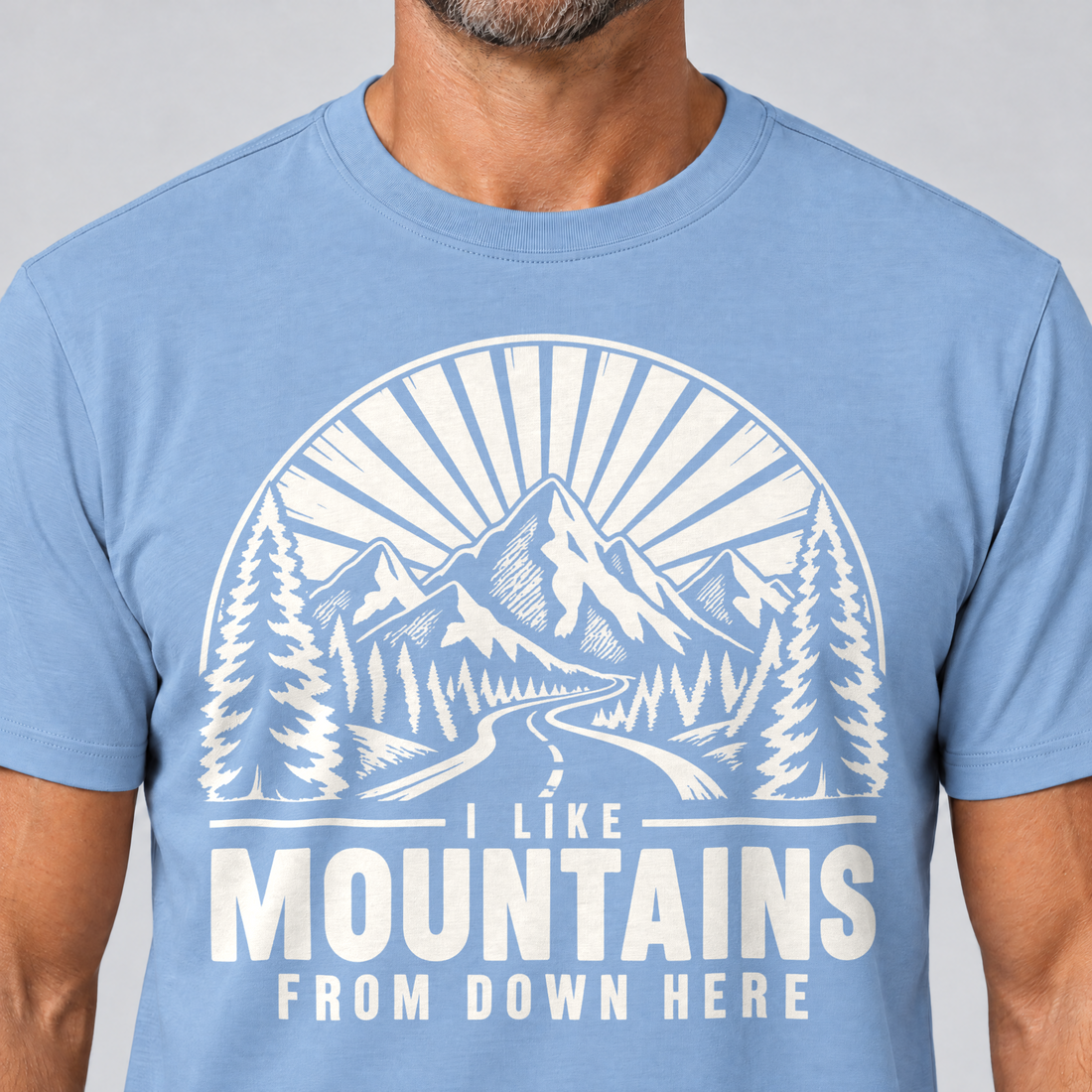 Nahaufnahme des Drucks: I like mountains from down here – T-Shirt Unisex in Himmelblau, von einem Mann getragen