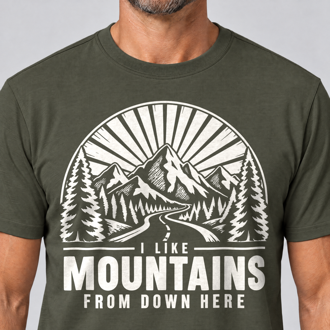 Nahaufnahme des Drucks: I like mountains from down here – T-Shirt Unisex in Oliv, von einem Mann getragen