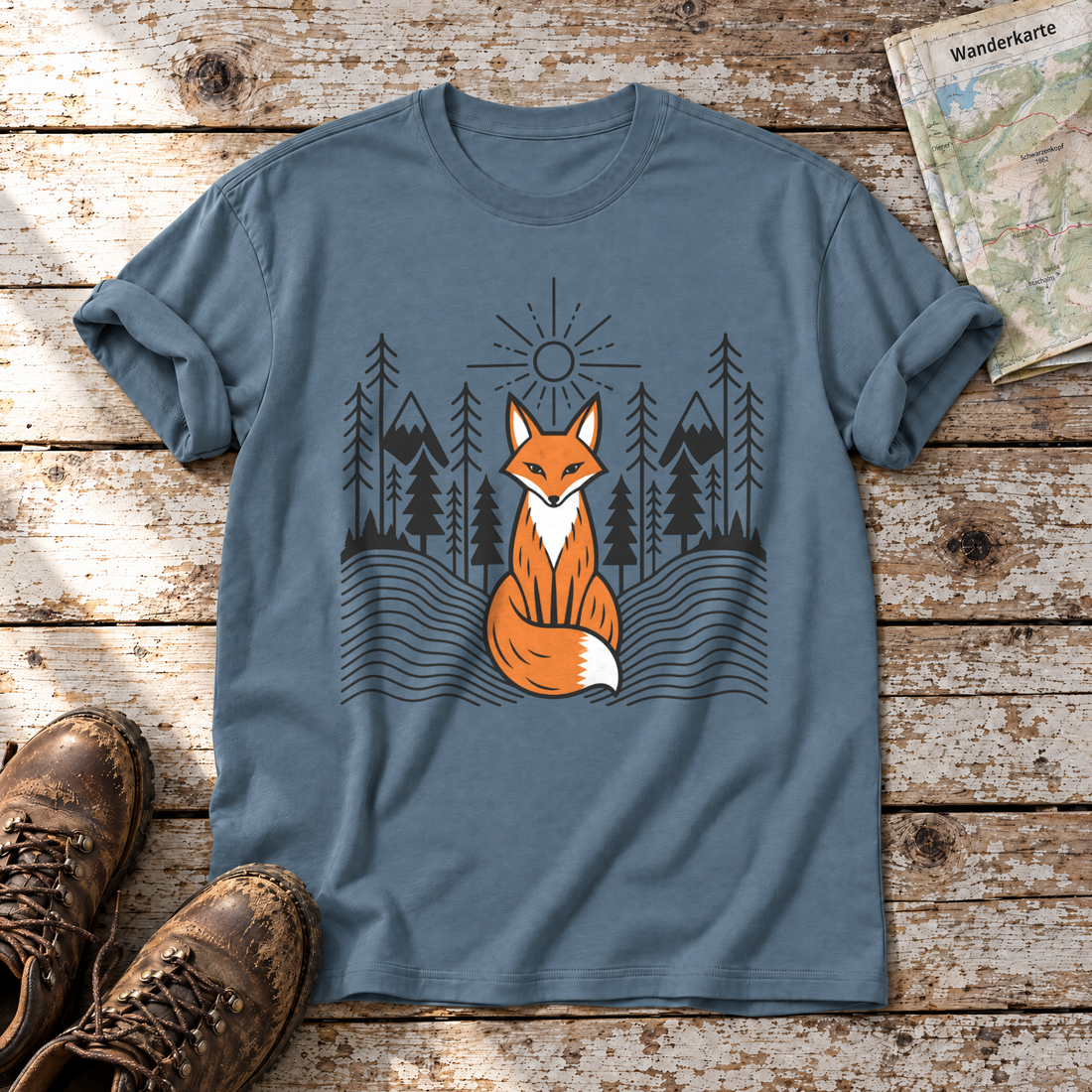 Fuchs im Tannenwald – T-Shirt Unisex in Steinblau, flach liegend auf alten Holzbrettern mit Wanderschuhen und Wanderkarte.
