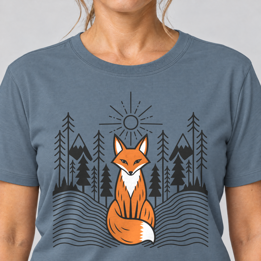 Nahaufnahme des Drucks: Fuchs im Tannenwald – T-Shirt Unisex in Steinblau, von einer Frau getragen