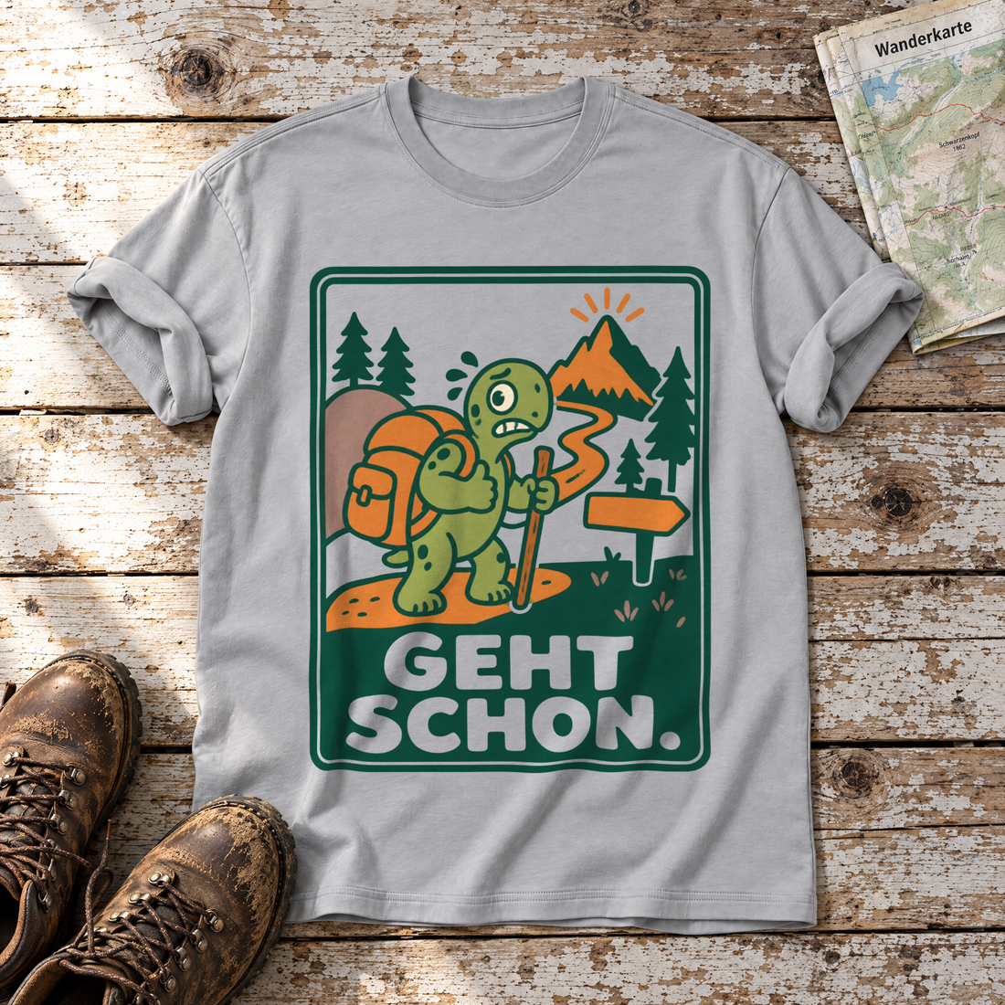 Geht schon – T-Shirt Unisex in Hellgrau, flach liegend auf alten Holzbrettern mit Wanderschuhen und Wanderkarte.