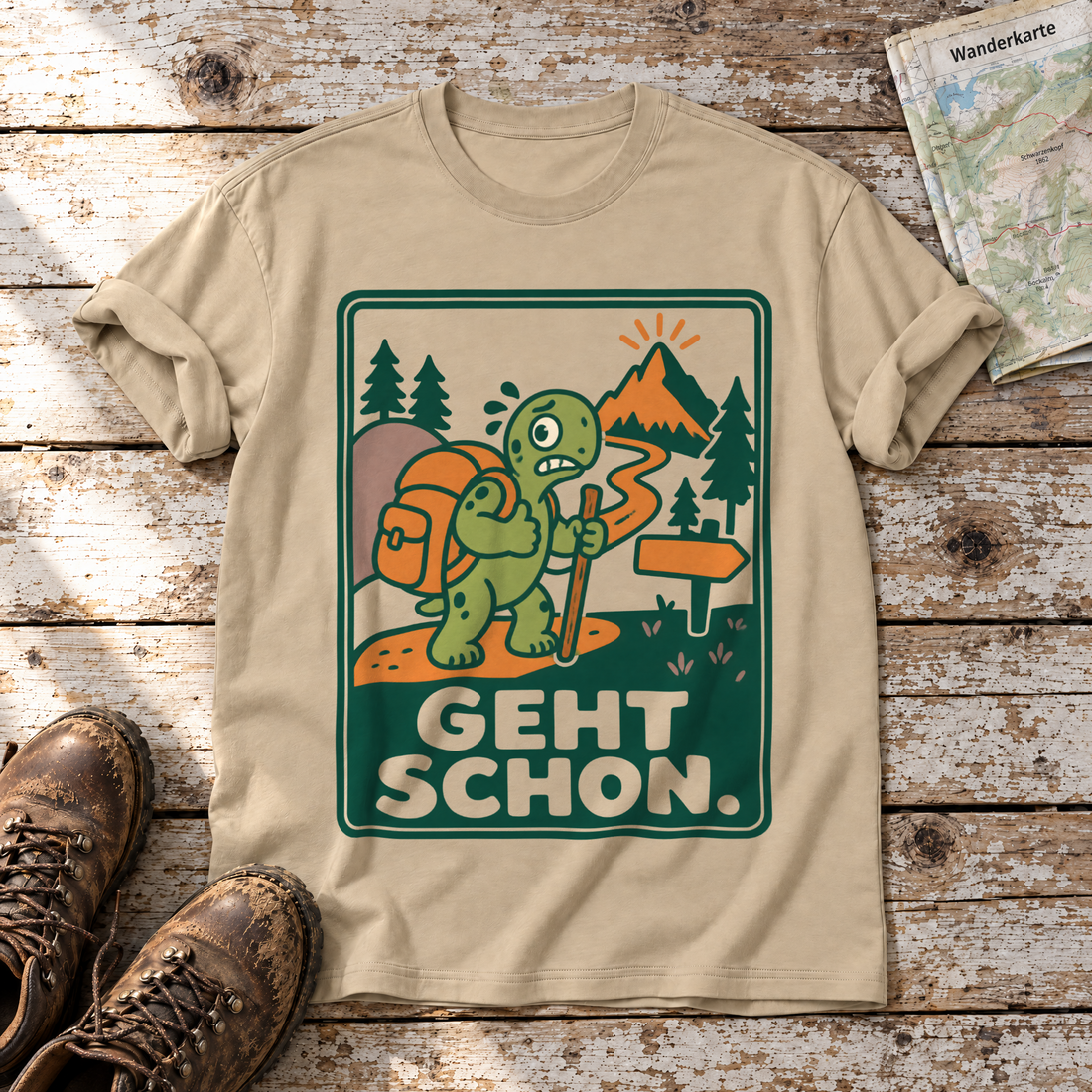 Geht schon – T-Shirt Unisex in Sand, flach liegend auf alten Holzbrettern mit Wanderschuhen und Wanderkarte.