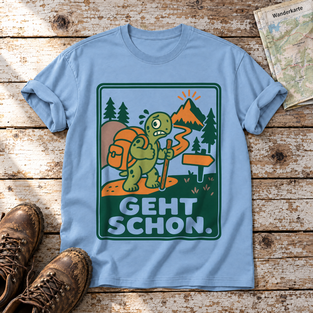 Geht schon – T-Shirt Unisex in Himmelblau, flach liegend auf alten Holzbrettern mit Wanderschuhen und Wanderkarte.