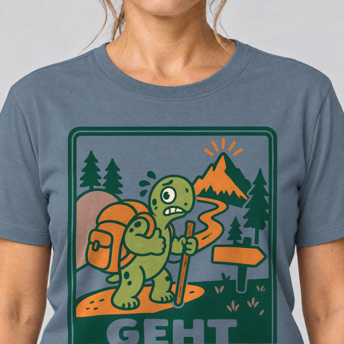 Nahaufnahme des Drucks: Geht schon – T-Shirt Unisex in Steinblau, von einer Frau getragen