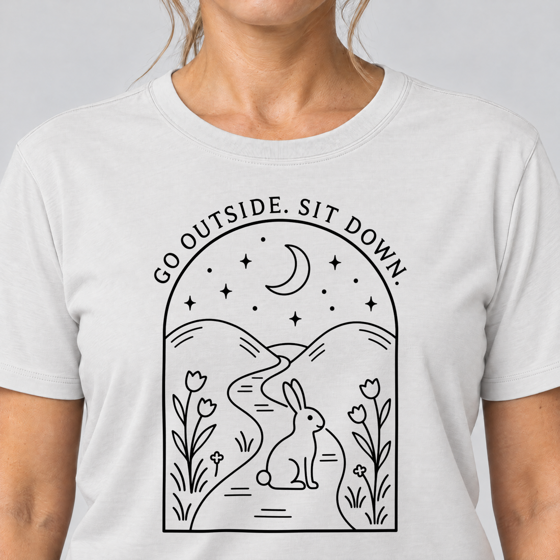 Nahaufnahme des Drucks: Go outside. Sit down. – T-Shirt Unisex in Weiß, von einer Frau getragen