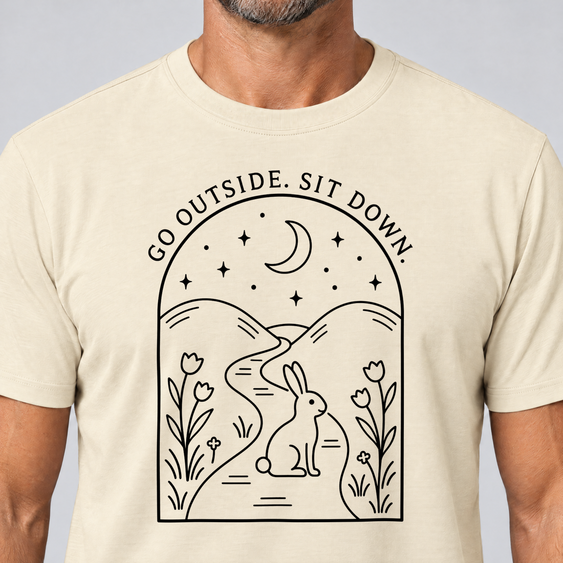 Nahaufnahme des Drucks: Go outside. Sit down. – T-Shirt Unisex in Natur, von einem Mann getragen