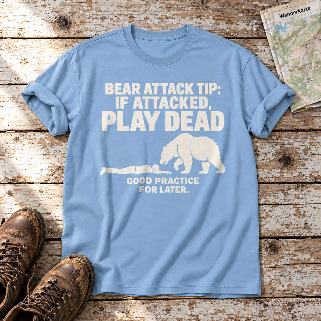 Good Practice for Later – T-Shirt Unisex in Himmelblau, flach liegend auf alten Holzbrettern mit Wanderschuhen und Wanderkarte.