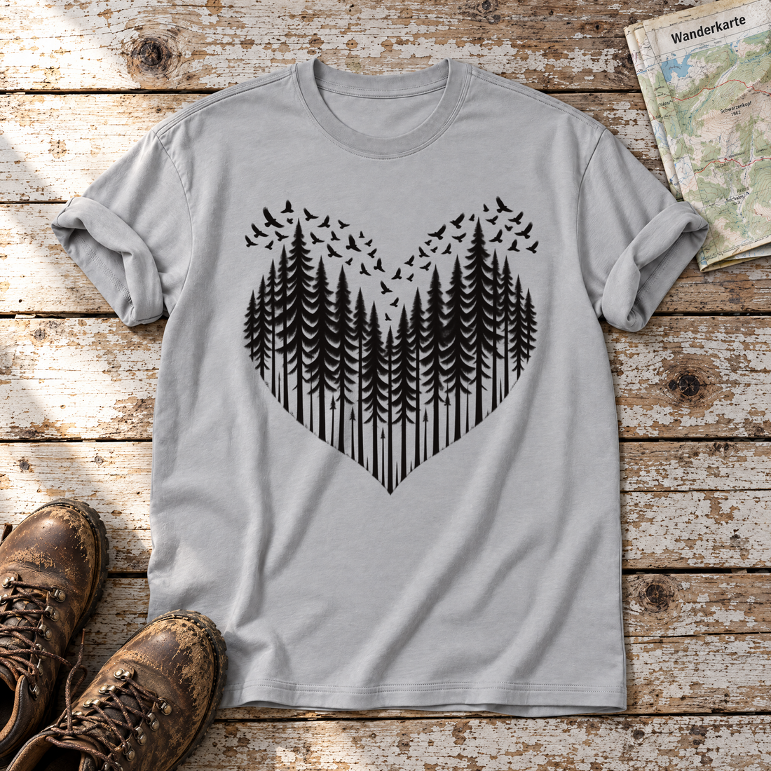 Bergwald-Herz mit Alpendohlen – T-Shirt Unisex in Hellgrau, flach liegend auf alten Holzbrettern mit Wanderschuhen und Wanderkarte.