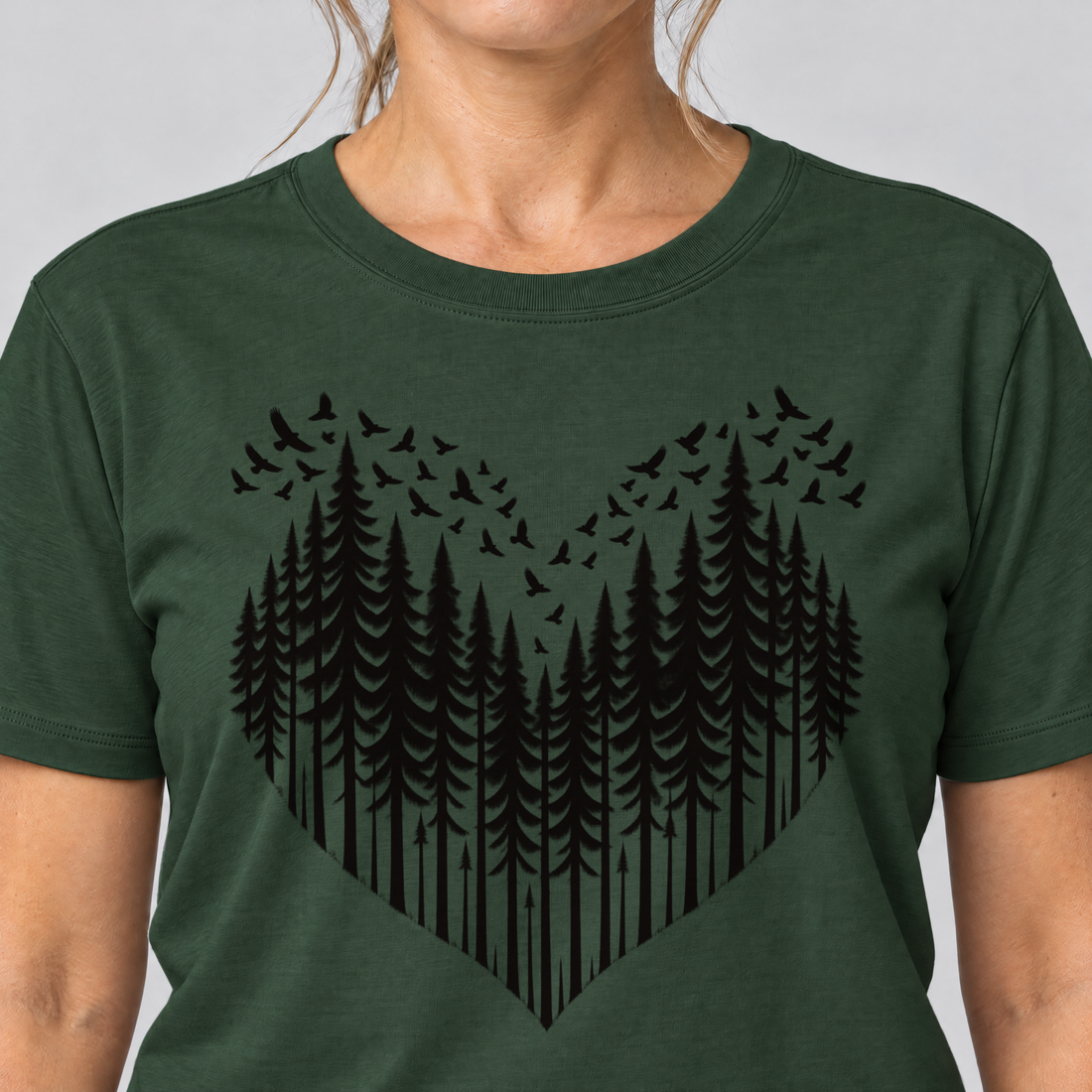 Nahaufnahme des Drucks: Bergwald-Herz mit Alpendohlen – T-Shirt Unisex in Flaschengrün, von einer Frau getragen