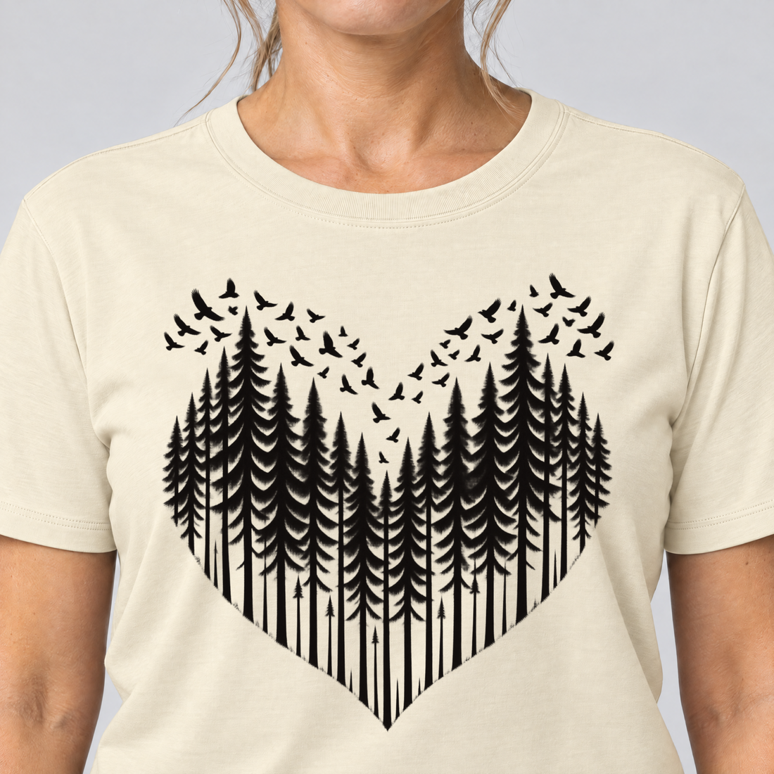 Nahaufnahme des Drucks: Bergwald-Herz mit Alpendohlen – T-Shirt Unisex in Natur, von einer Frau getragen
