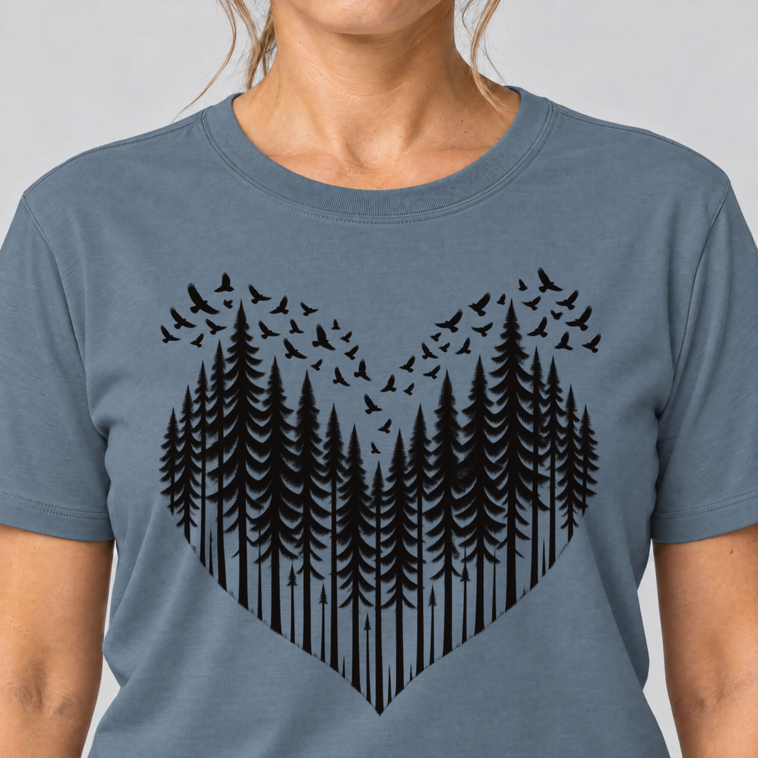 Nahaufnahme des Drucks: Bergwald-Herz mit Alpendohlen – T-Shirt Unisex in Steinblau, von einer Frau getragen