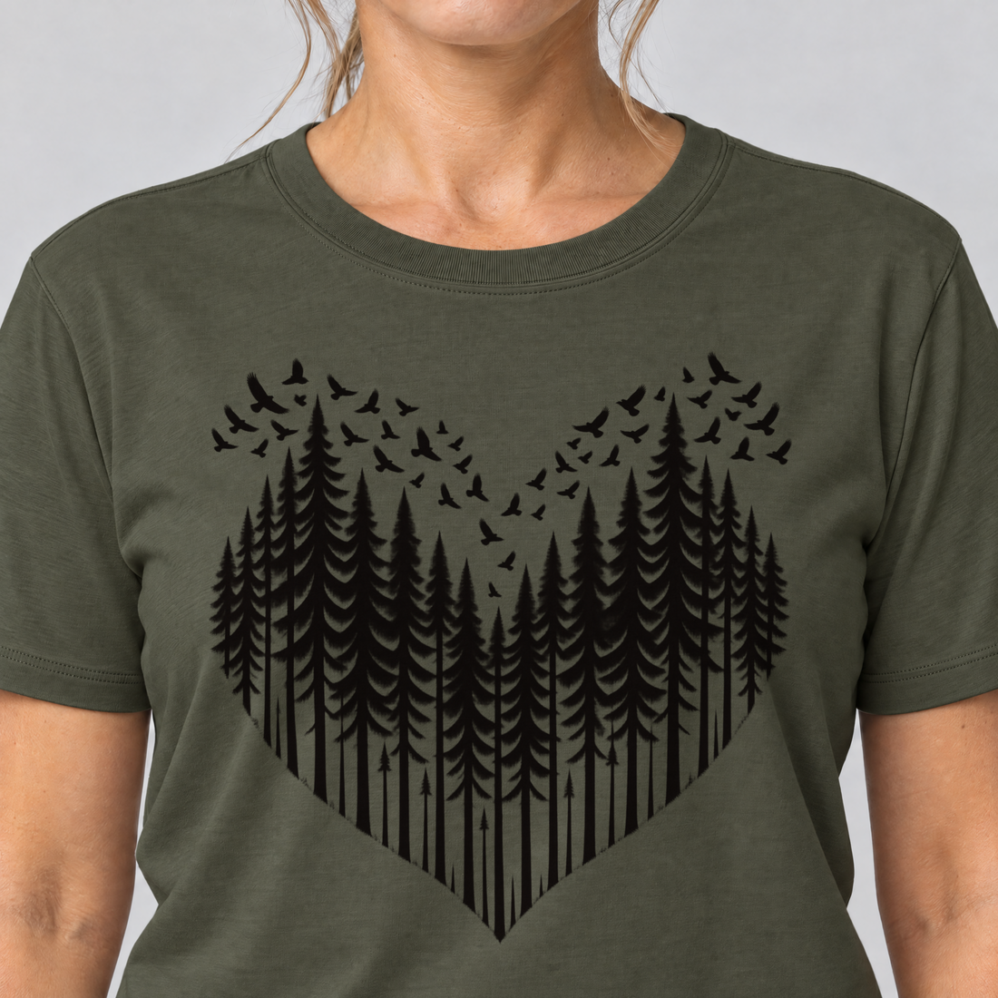 Nahaufnahme des Drucks: Bergwald-Herz mit Alpendohlen – T-Shirt Unisex in Oliv, von einer Frau getragen