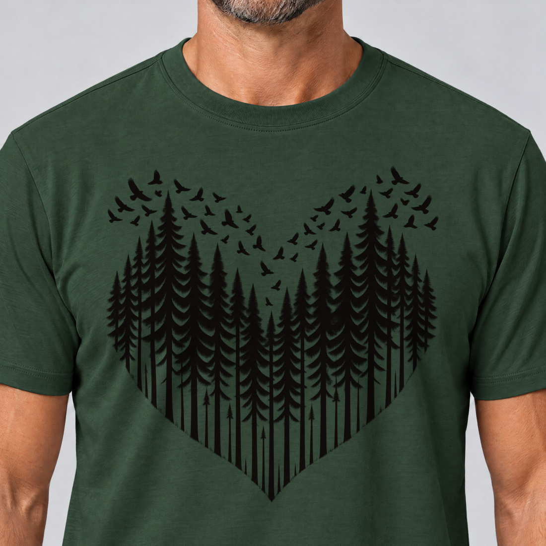Nahaufnahme des Drucks: Bergwald-Herz mit Alpendohlen – T-Shirt Unisex in Flaschengrün, von einem Mann getragen