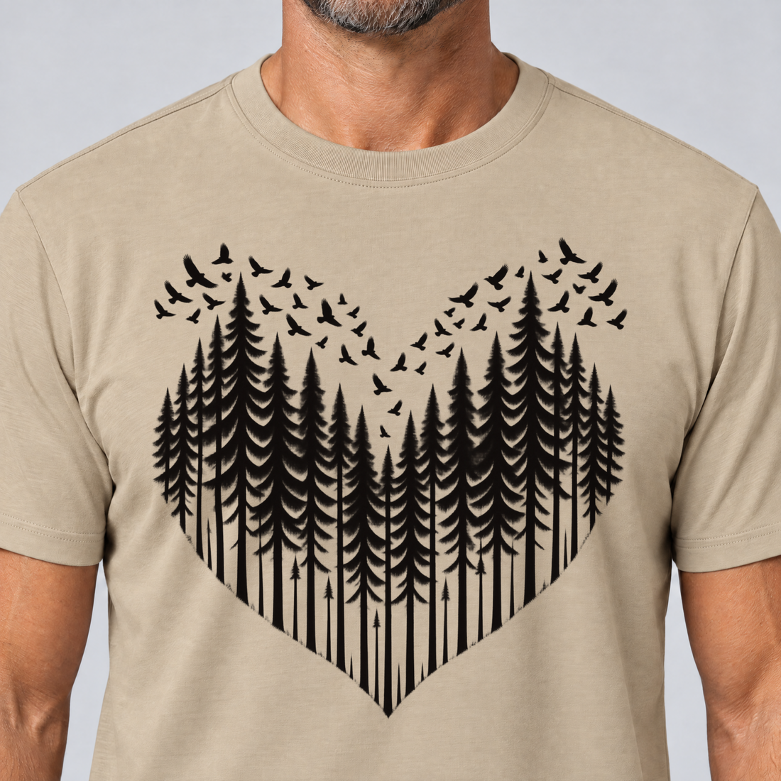 Nahaufnahme des Drucks: Bergwald-Herz mit Alpendohlen – T-Shirt Unisex in Sand, von einem Mann getragen