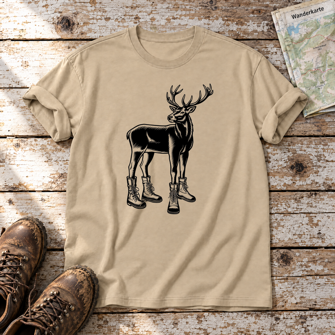 Hirsch in Bergschuhen – T-Shirt Unisex in Sand, flach liegend auf alten Holzbrettern mit Wanderschuhen und Wanderkarte.