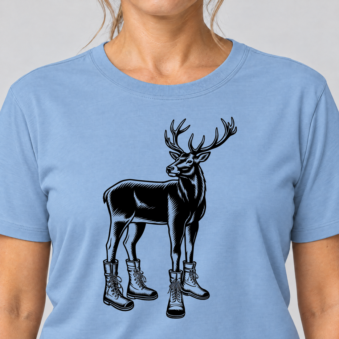 Nahaufnahme des Drucks: Hirsch in Bergschuhen – T-Shirt Unisex in Himmelblau, von einer Frau getragen
