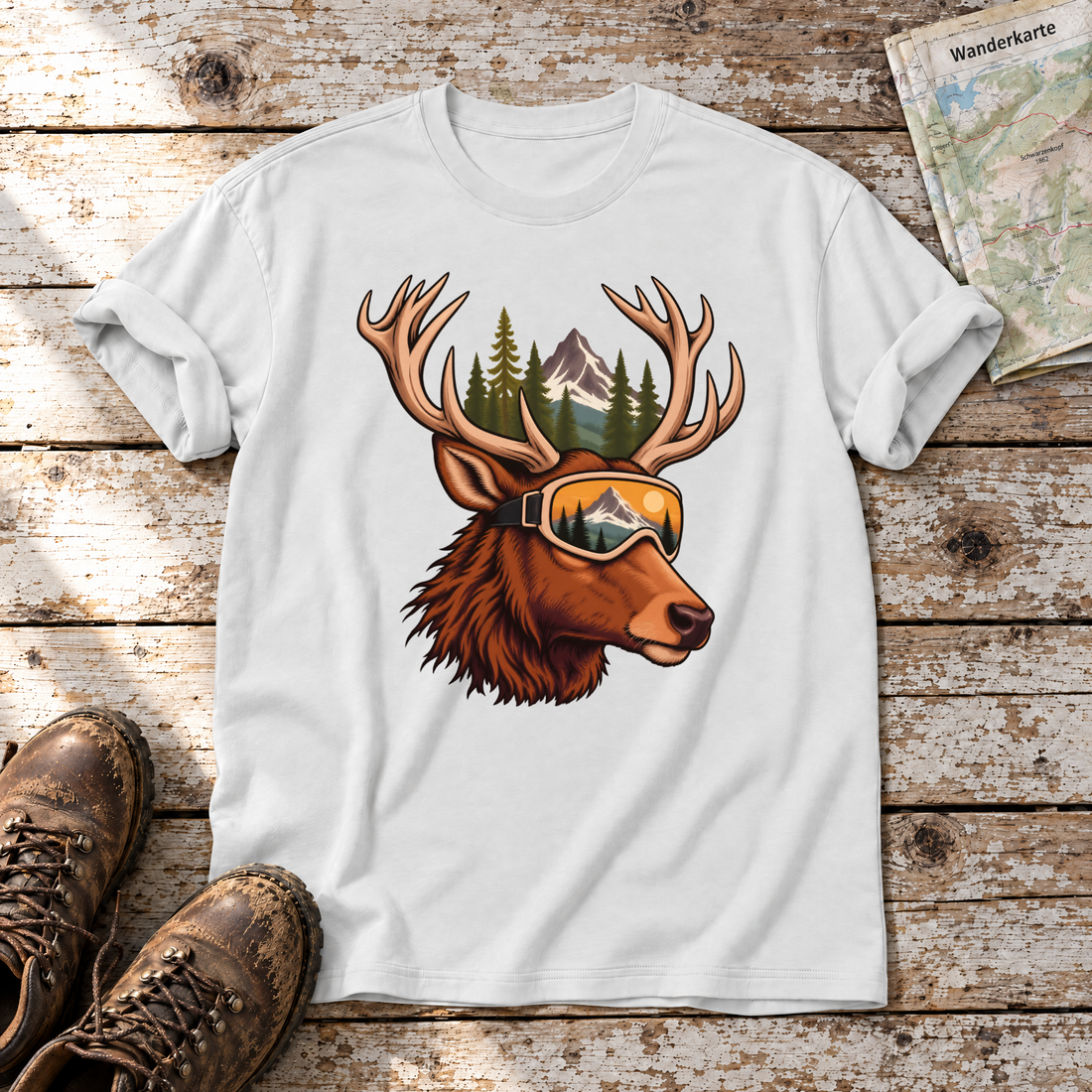 Hirsch mit Skibrille – T-Shirt Unisex in Weiß, flach liegend auf alten Holzbrettern mit Wanderschuhen und Wanderkarte.