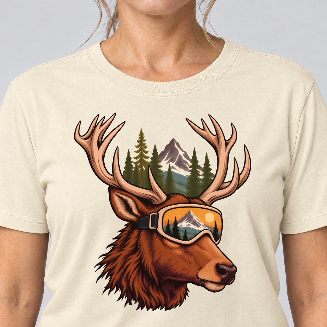 Nahaufnahme des Drucks: Hirsch mit Skibrille – T-Shirt Unisex in Natur, von einer Frau getragen
