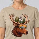 Nahaufnahme des Drucks: Hirsch mit Skibrille – T-Shirt Unisex in Sand, von einer Frau getragen