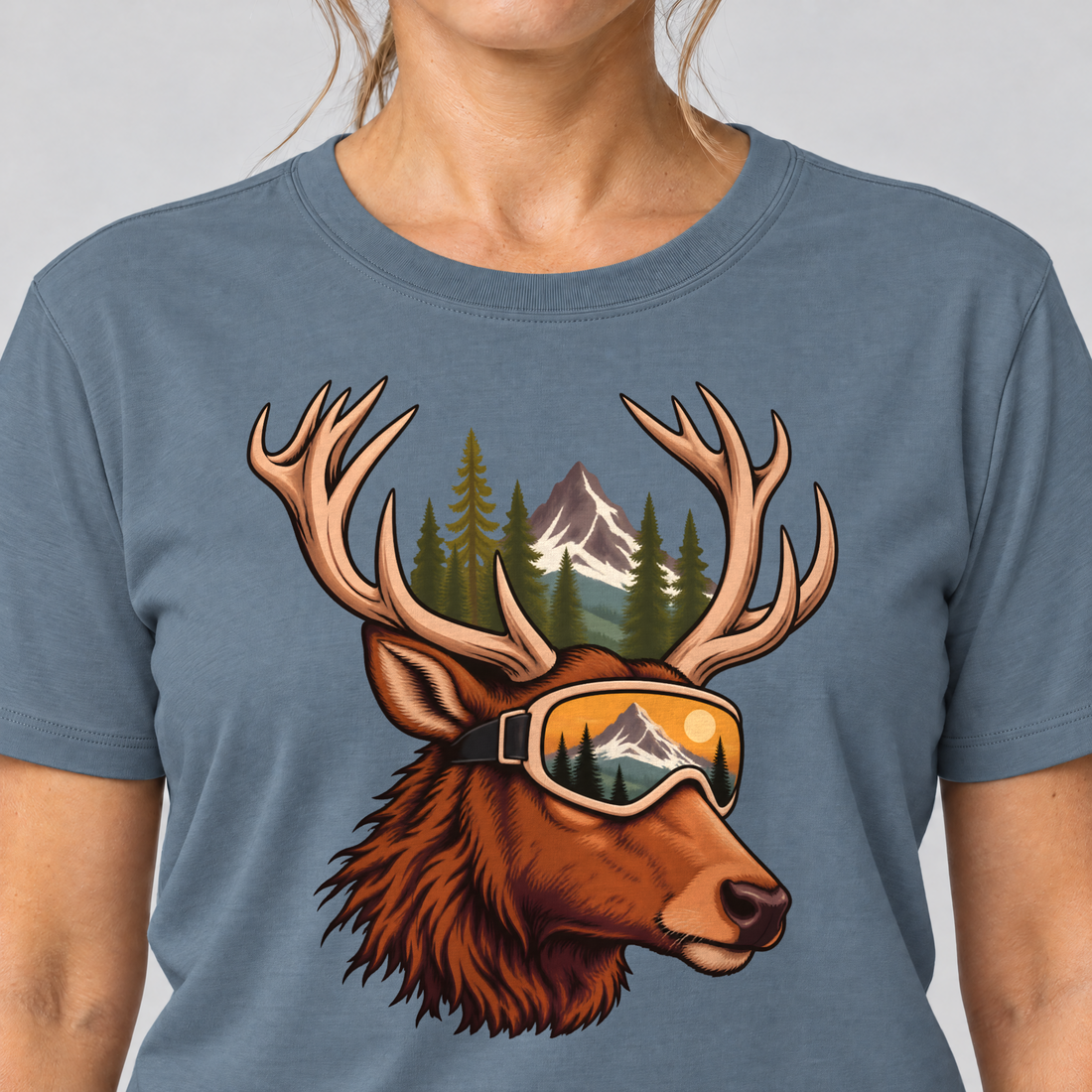 Nahaufnahme des Drucks: Hirsch mit Skibrille – T-Shirt Unisex in Steinblau, von einer Frau getragen