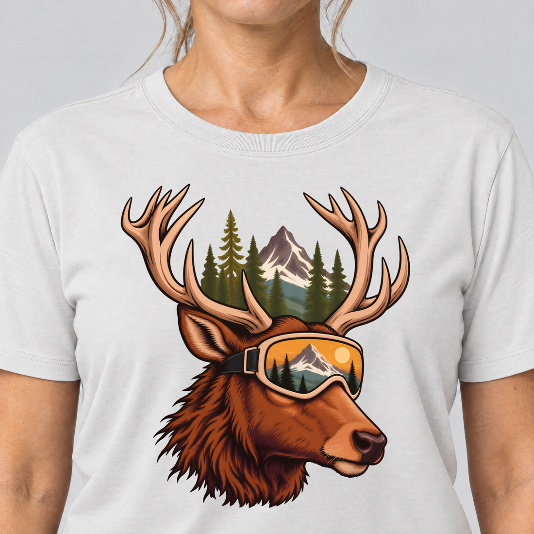 Nahaufnahme des Drucks: Hirsch mit Skibrille – T-Shirt Unisex in Weiß, von einer Frau getragen