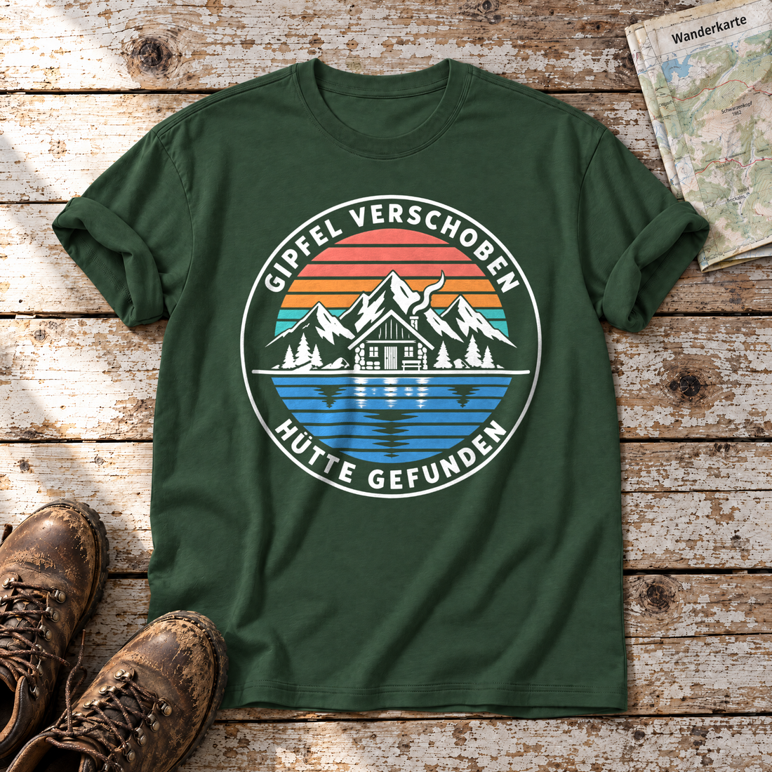 Gipfel verschoben, Hütte gefunden – T-Shirt Unisex in Flaschengrün, flach liegend auf alten Holzbrettern mit Wanderschuhen und Wanderkarte.