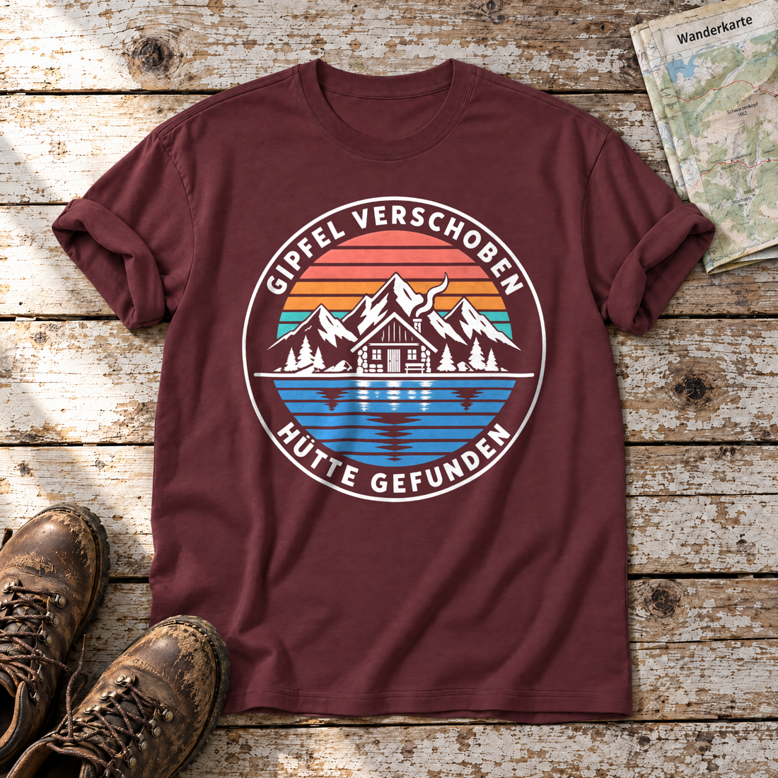 Gipfel verschoben, Hütte gefunden – T-Shirt Unisex in Bordeaux, flach liegend auf alten Holzbrettern mit Wanderschuhen und Wanderkarte.