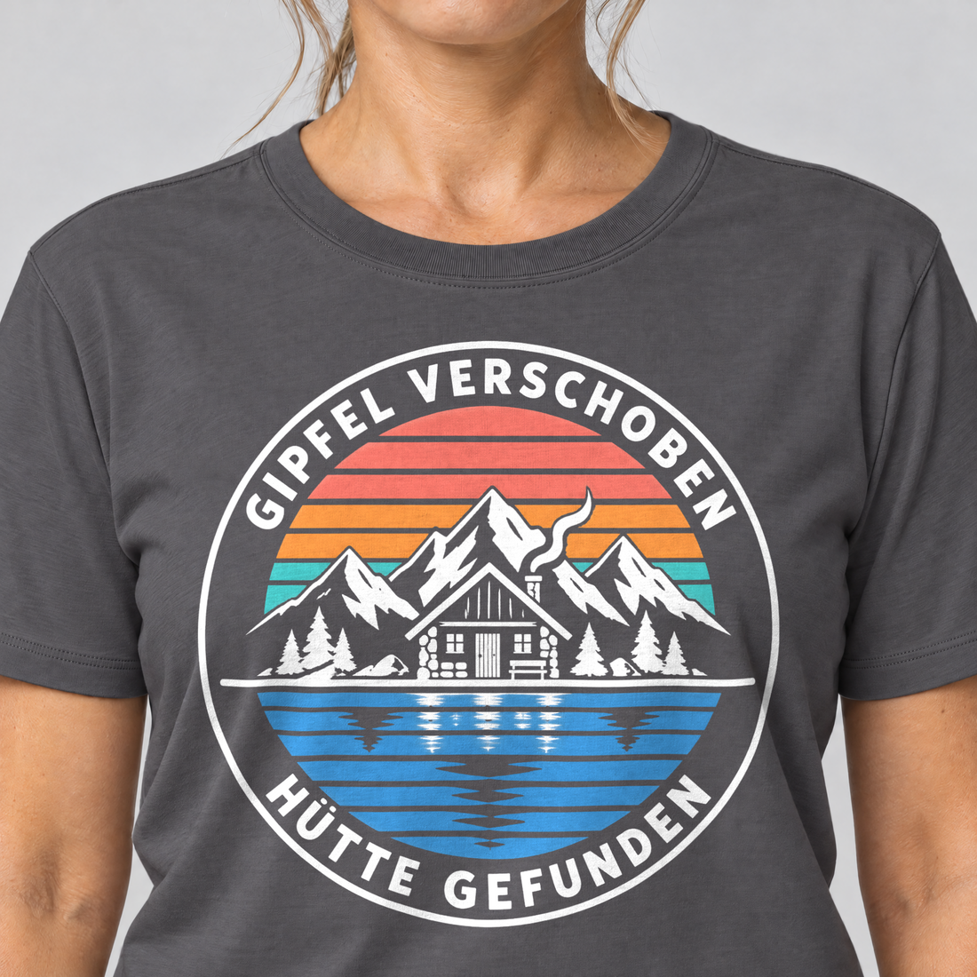 Nahaufnahme des Drucks: Gipfel verschoben, Hütte gefunden – T-Shirt Unisex in Dunkelgrau, von einer Frau getragen
