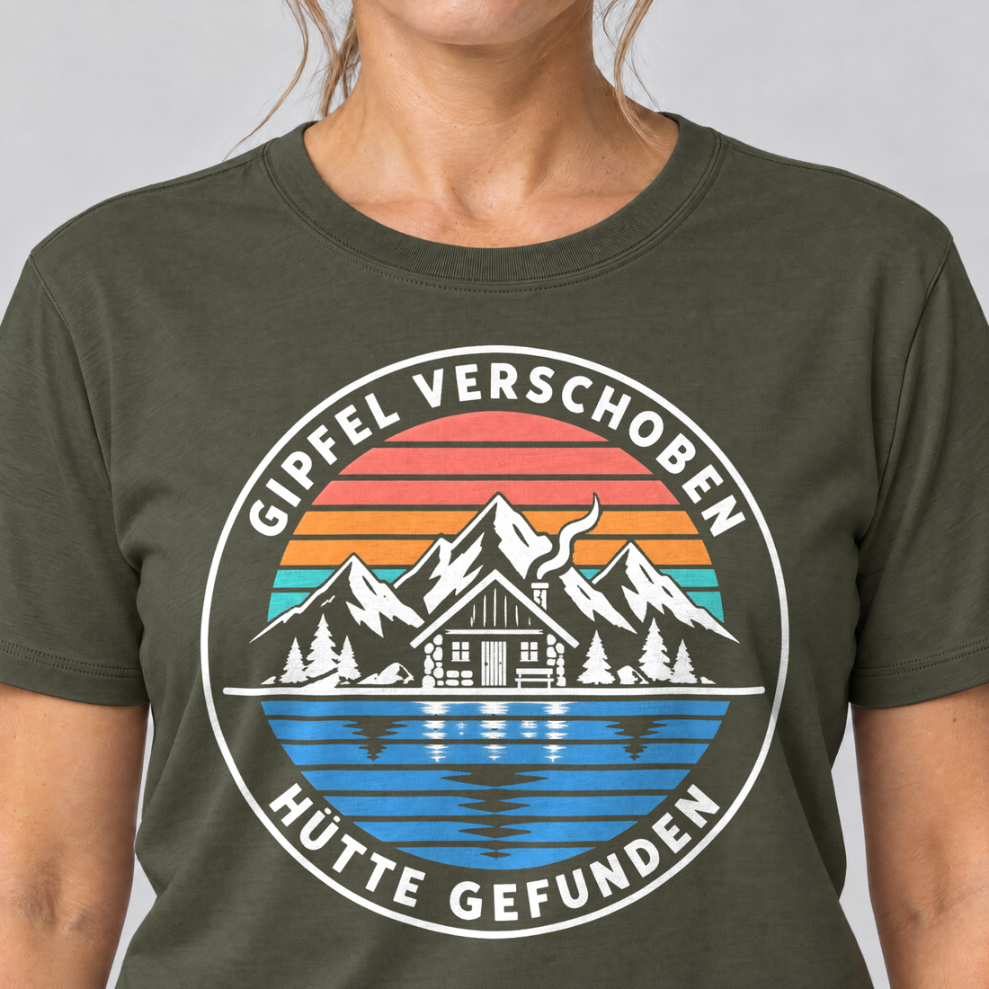 Nahaufnahme des Drucks: Gipfel verschoben, Hütte gefunden – T-Shirt Unisex in Oliv, von einer Frau getragen