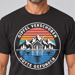 Nahaufnahme des Drucks: Gipfel verschoben, Hütte gefunden – T-Shirt Unisex in Schwarz, von einem Mann getragen