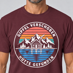 Nahaufnahme des Drucks: Gipfel verschoben, Hütte gefunden – T-Shirt Unisex in Bordeaux, von einem Mann getragen