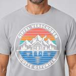 Nahaufnahme des Drucks: Gipfel verschoben, Hütte gefunden – T-Shirt Unisex in Hellgrau, von einem Mann getragen
