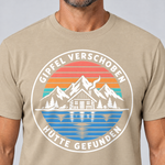Nahaufnahme des Drucks: Gipfel verschoben, Hütte gefunden – T-Shirt Unisex in Sand, von einem Mann getragen