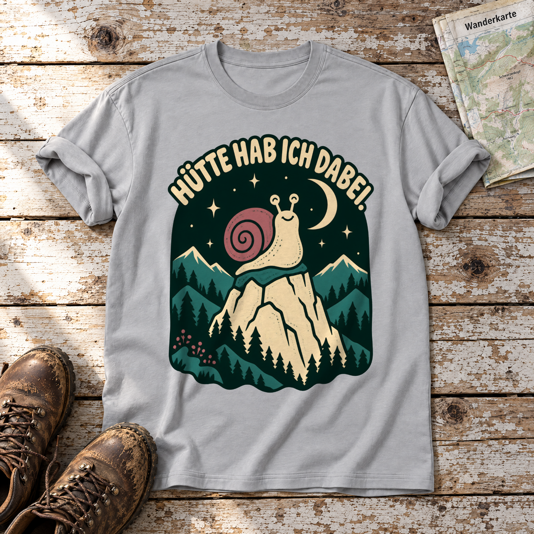 Hütte hab ich dabei – T-Shirt Unisex in Hellgrau, flach liegend auf alten Holzbrettern mit Wanderschuhen und Wanderkarte.