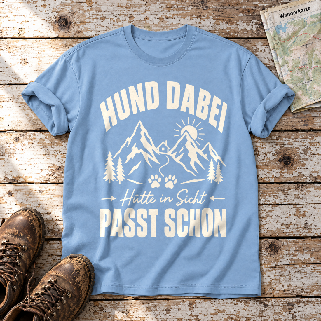 Hütte in Sicht, passt schon – T-Shirt Unisex in Himmelblau, flach liegend auf alten Holzbrettern mit Wanderschuhen und Wanderkarte.