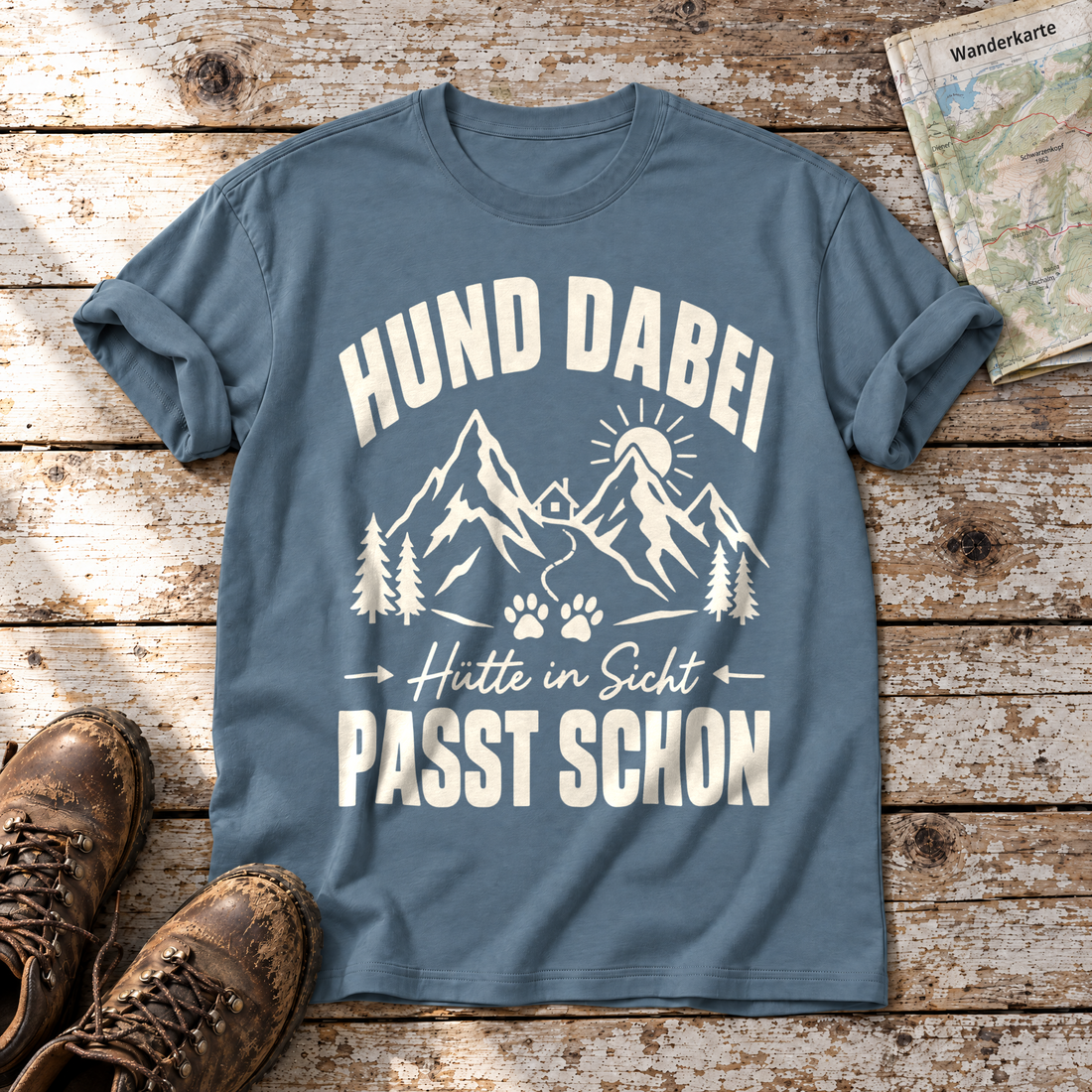 Hütte in Sicht, passt schon – T-Shirt Unisex in Steinblau, flach liegend auf alten Holzbrettern mit Wanderschuhen und Wanderkarte.