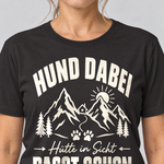Nahaufnahme des Drucks: Hütte in Sicht, passt schon – T-Shirt Unisex in Schwarz, von einer Frau getragen