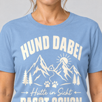Nahaufnahme des Drucks: Hütte in Sicht, passt schon – T-Shirt Unisex in Himmelblau, von einer Frau getragen