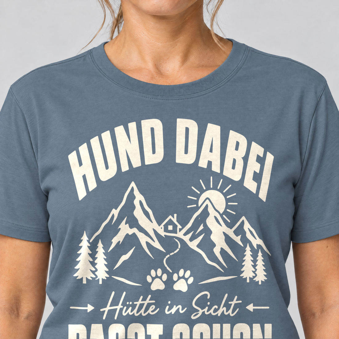 Nahaufnahme des Drucks: Hütte in Sicht, passt schon – T-Shirt Unisex in Steinblau, von einer Frau getragen