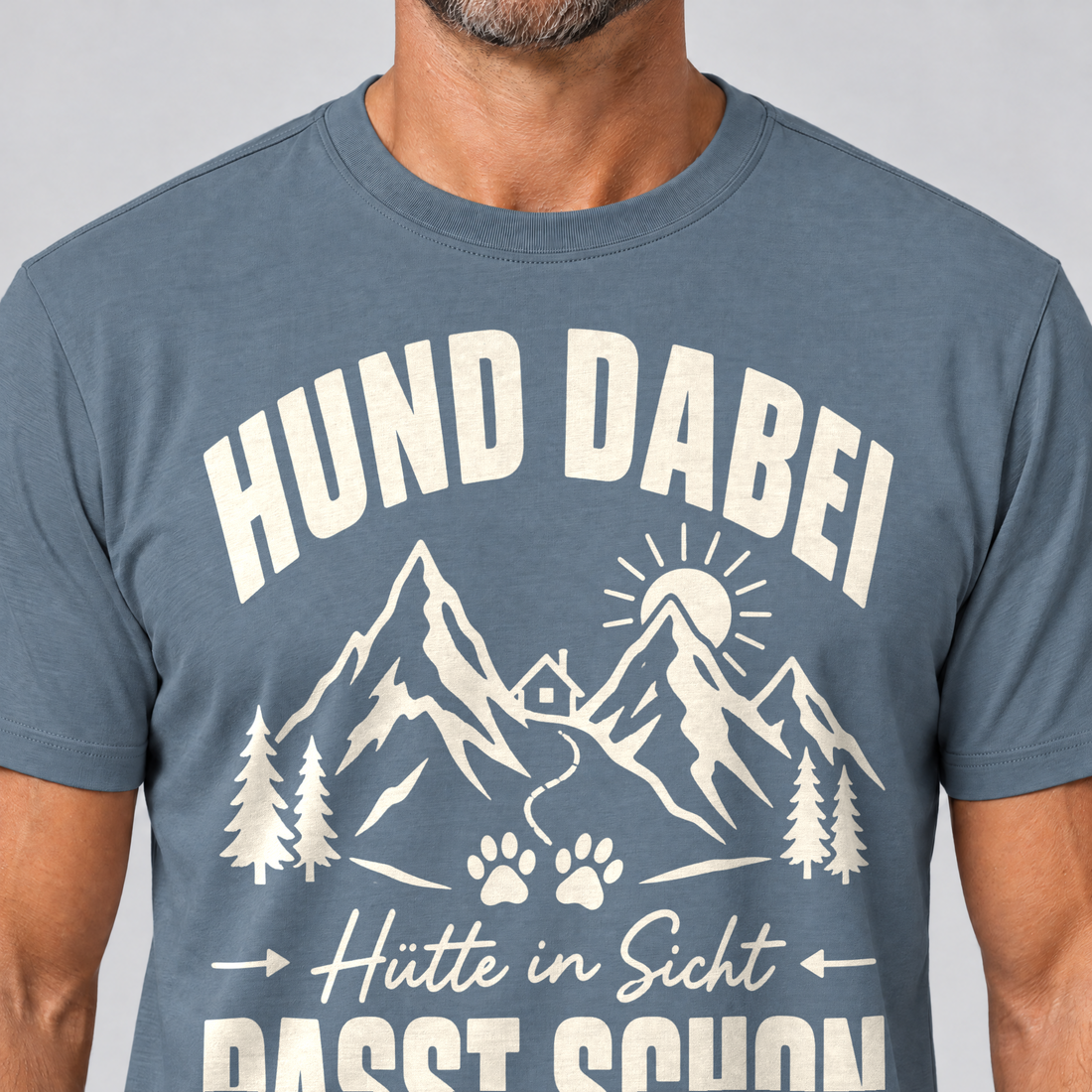 Nahaufnahme des Drucks: Hütte in Sicht, passt schon – T-Shirt Unisex in Steinblau, von einem Mann getragen