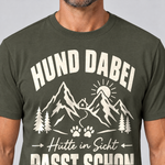 Nahaufnahme des Drucks: Hütte in Sicht, passt schon – T-Shirt Unisex in Oliv, von einem Mann getragen